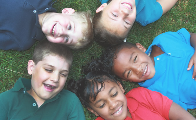 Children Smiling in the Grass